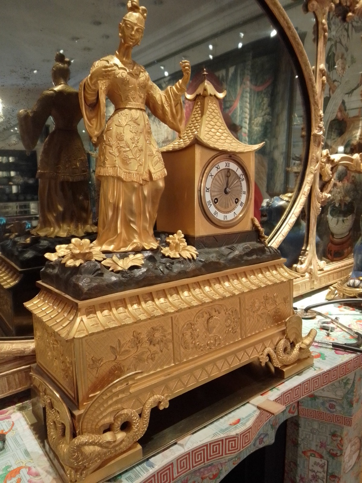 Reloj con sonería y figura de estilo chinesco revestida en dorado a la hoja
