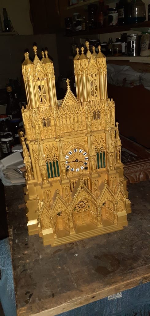 Reloj montado en una réplica a escala de la fachada oeste de la Catedral de Notre-Dame de Reims (Francia), revestida en dorado a la hoja